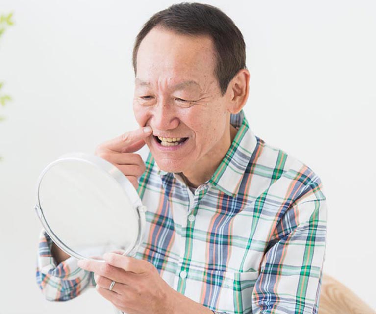 歯周病のチェックをする中年男性