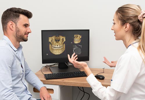CT画像を患者に説明する歯科医師